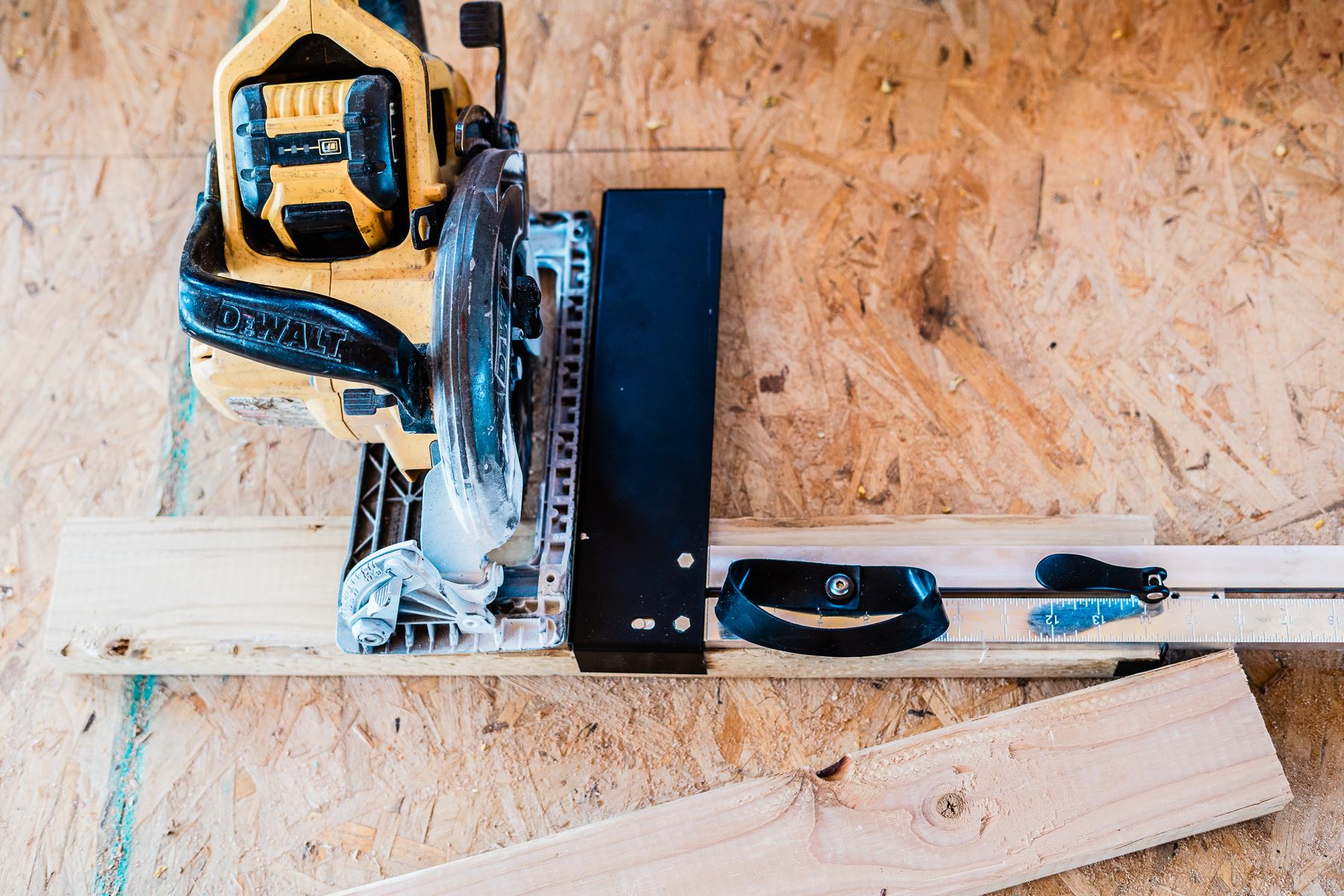 A circular saw riding the CutBoss fence to cut a 2x block to length